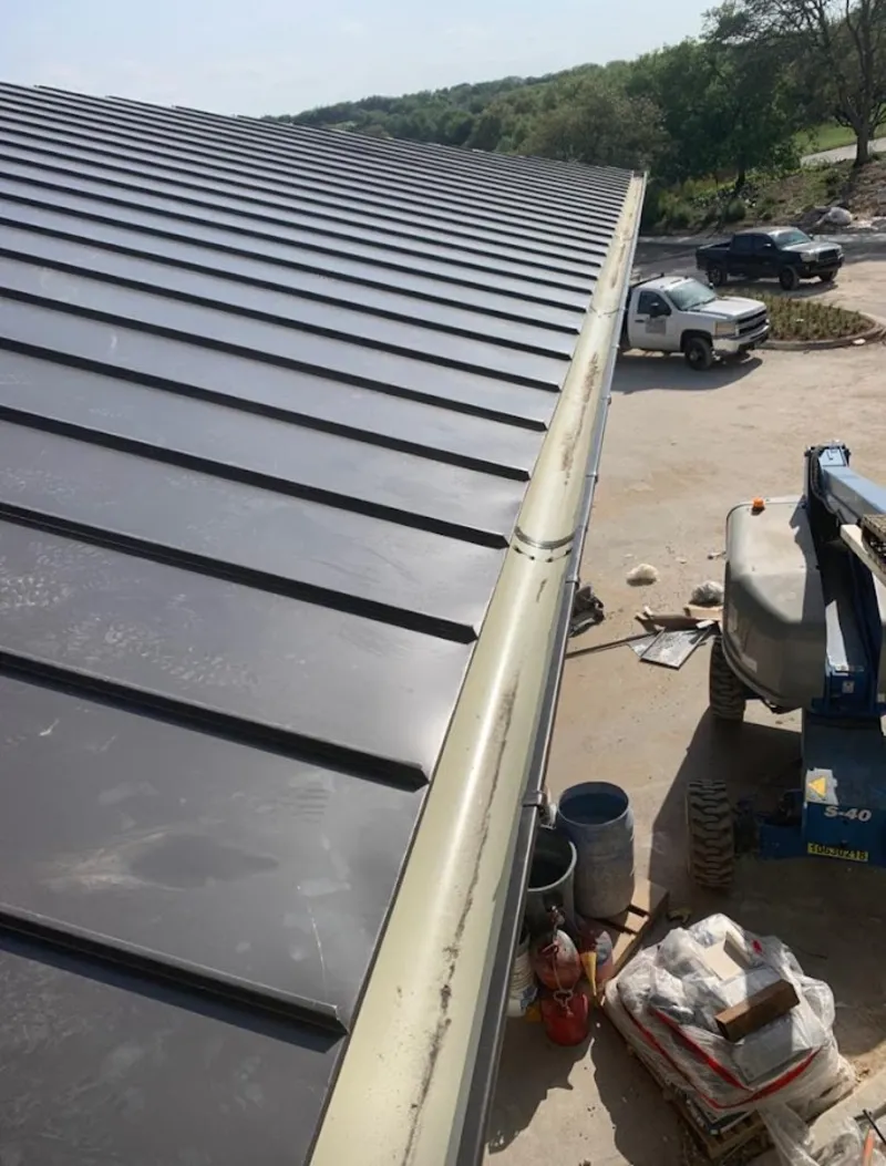 Standing seam panel and gutter detail on a metal roofing jobsite in Vidor
